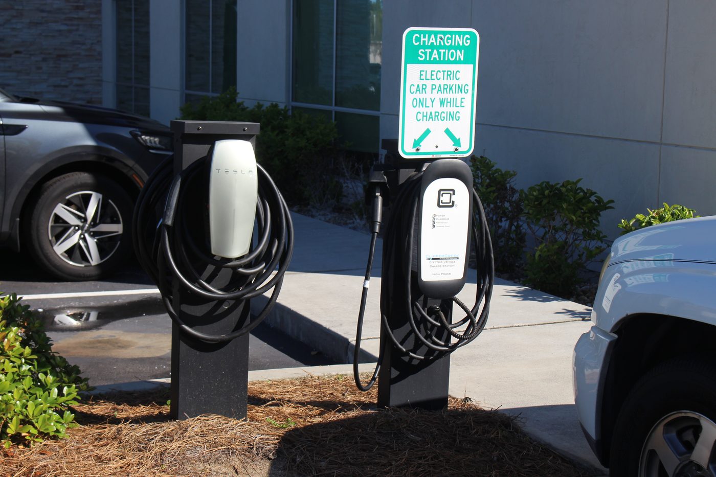 Row of Tesla destination chargers in a hotel parking lot
