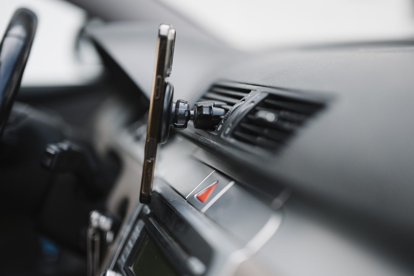 Smartphone mounted on a dashboard during EV navigation — the operator app is one tab away