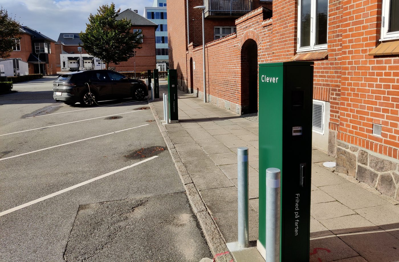 Designated parking spaces for electric vehicles in Esbjerg, Denmark — marked white EV symbols on tarmac
