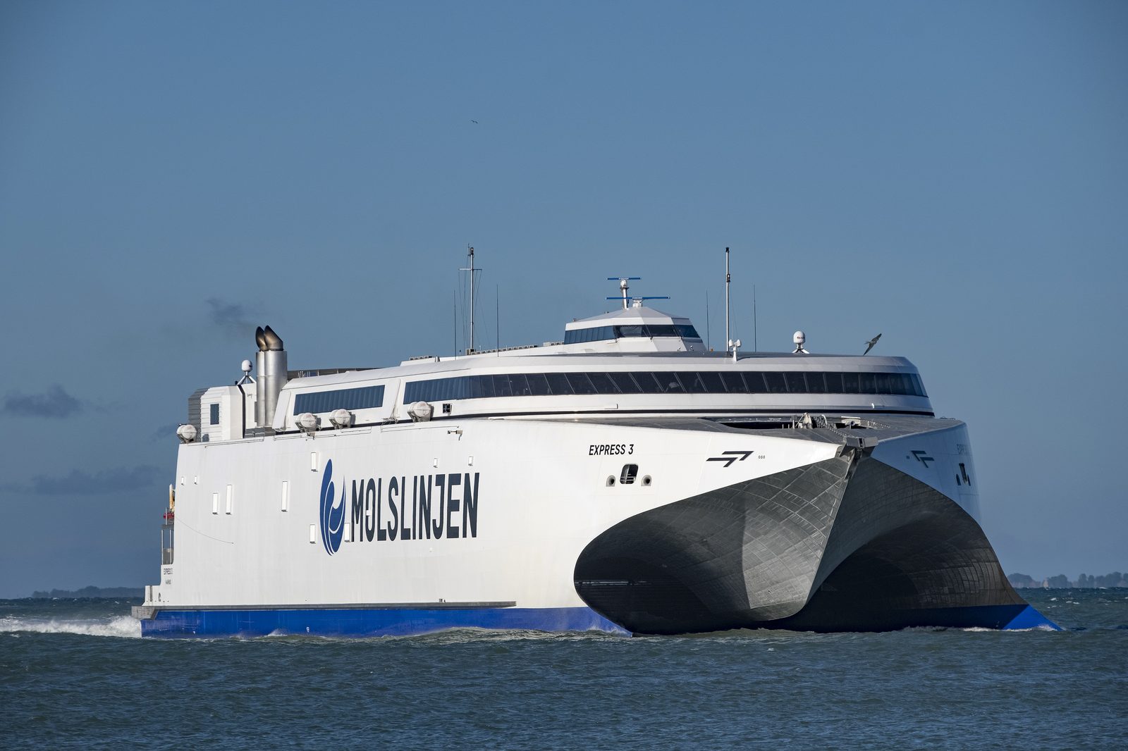 Fast catamaran of the Bornholmslinjen class crossing the Baltic — bow lifted, foam wake behind
