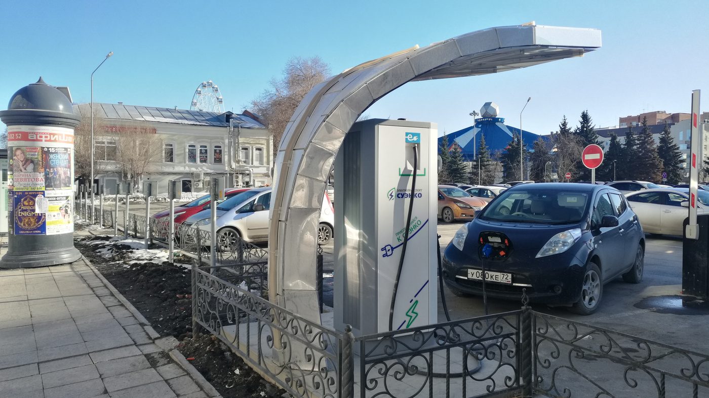 Electric vehicle plugged into an outdoor charger surrounded by snow