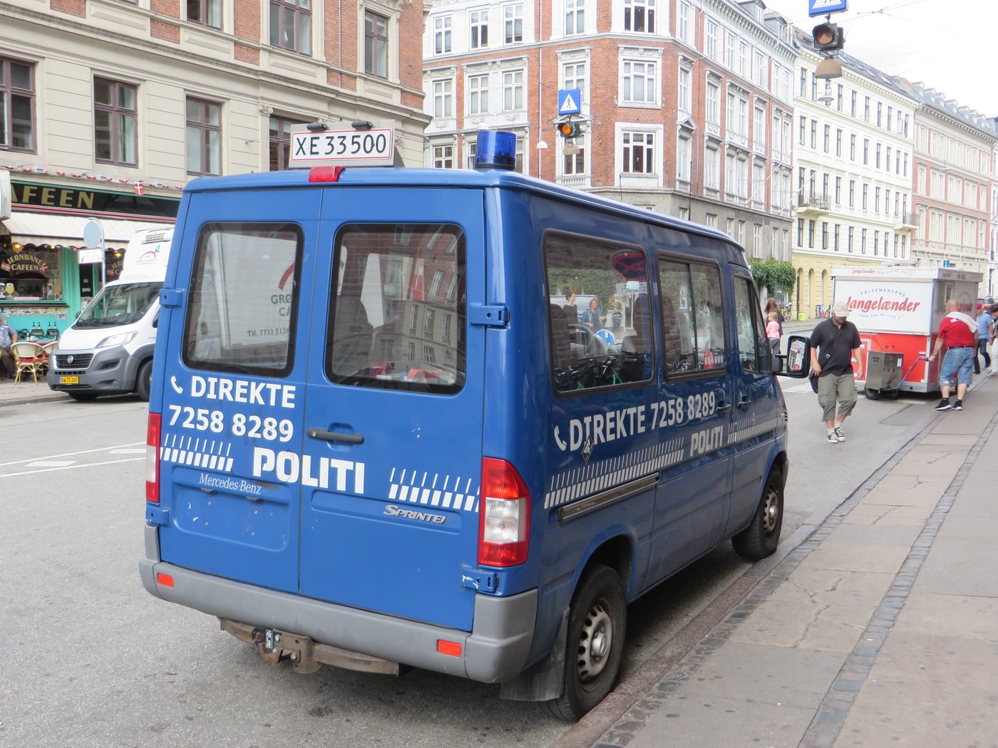 Danish police car on a Copenhagen street — the white-and-blue Politi livery that signals a roadside stop is also an option